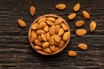 In a bowl overflowing with dried almonds - Prunus dulcis