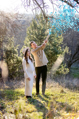 Happy couple happily celebrating their pregnancy surrounded by blue confetti