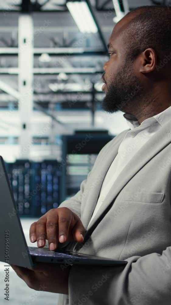 Poster vertical video engineer in data center using laptop to update storage arrays, configuring network vi