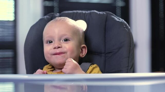 A baby joyfully enjoys meals in a high chair, delighting in food