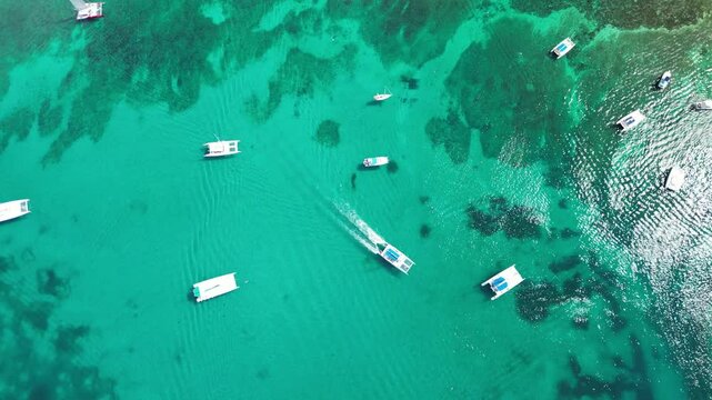Drone footage capturing excursion boats lined up along the coast of Bayahibe on a bright sunny day. Filmed 14 November 2024