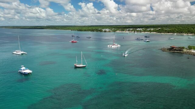 Aerial shot of vibrant catamarans and speedboats used for tourist excursions in the Caribbean. Filmed at Bayahibe bay in the Dominican Republic