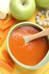 Baby food. Tasty puree in bowl, different ingredients and teether on table, flat lay