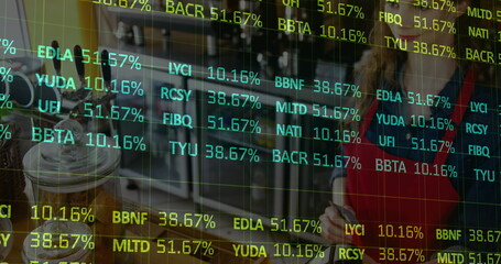 Overlaying financial tickers over cafe, with barista wearing red apron serving iced coffee jar