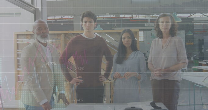 Standing diverse team of four professionals analyzing graph overlays in makerspace, with worktable - Powered by Adobe