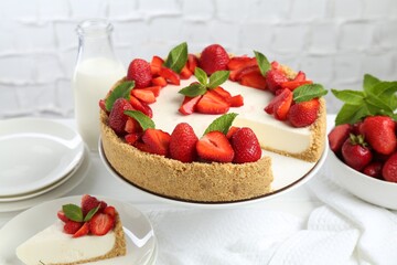 Delicious cheesecake with strawberries, mint and milk on table, closeup