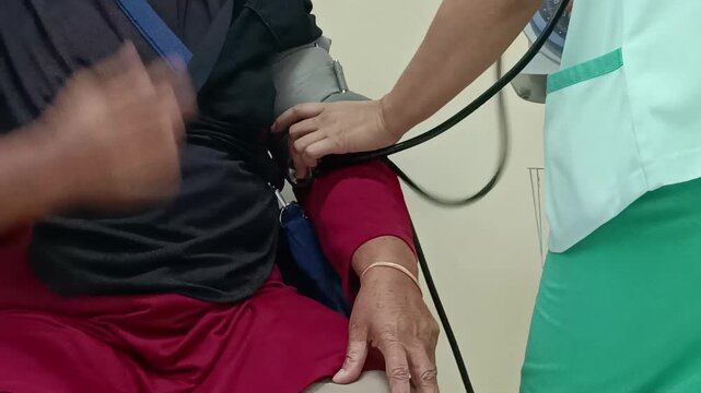 Close-up video shows a blood pressure checkup. A nurse uses a sphygmomanometer to measure the patient's bp, promoting a healthy lifestyle awareness.