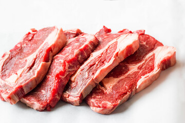 Uncooked,sliced rib steaks on oven baking paper,above view