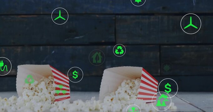 Dropping popcorn tubs spilling kernels green icons floating and circling showing sustainability