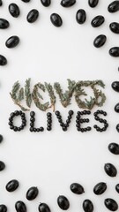 Black olives spelling out the word olives with thyme on a white background in a flat lay style