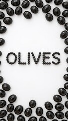 Arrangement of black olives forming the word olives on a white background in a studio shot