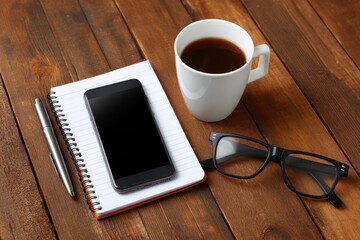 Smartphone on Wooden Table with Coffee Cup Notebook and Glasses for Business Use