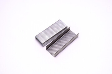 A clean image of stacked metal staples isolated on a white background. Ideal for office, stationery, or minimalist design themes with emphasis on structure and precision