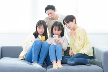 困った顔をしながらスマートフォンを使う親子