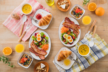 【こんがりベーコンが主役の朝食イメージ】クロワッサンとパンプキンスープ。エッグサラダとキャロットラペ。こんがりベーコン。ミューズリーとオレンジジュース。