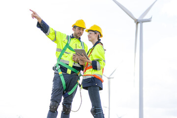 Engineer team man and woman working together with tablet,  survey plan construction wind turbine...