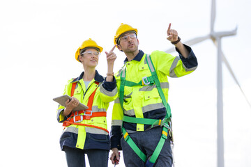 Engineer team man and woman working together with tablet,  survey plan construction wind turbine...
