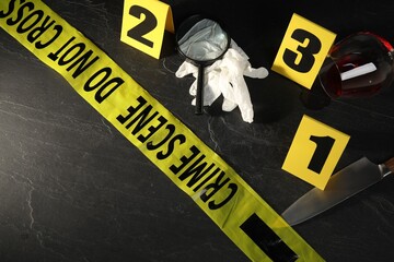 Forensic expert. Yellow crime scene tape, markers and evidences on black table, above view. Space...