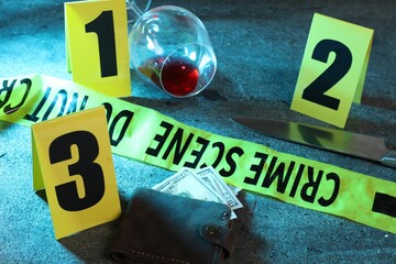 Forensic expert. Yellow crime scene tape, markers, wallet with money, knife and glass of wine on...