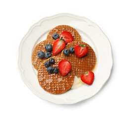 Tasty Dutch waffles (stroopwafels) with honey, strawberries and blueberries isolated on white, top view