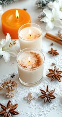 Two candles, one orange, one cream, surrounded by wintery decor