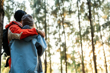 Couple Hugging in Forest at Sunset. Rear View of Romantic Travelers in Warm Winter Clothes Standing Together, Embracing Peacefully While Enjoying the Tranquil Nature and Soft Golden Light