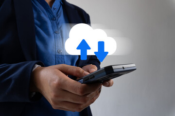 A person's hands holding a cell phone with virtual cloud icons and arrows. Concept of uploading and downloading data from the cloud.