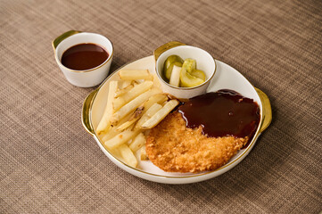 Crispy Pork Cutlet with French Fries, Pickles, and Sauce on Elegant Plate
