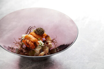 Exquisite fine dining dish with sea urchin, caviar & artistic plating in curved bowl. Premium...
