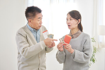ポチ袋を持ってお年玉の金額の相談をするシニア男性と女性