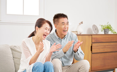 Fototapeta premium テレビを見るシニアの夫婦 リビング