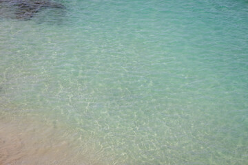 Crystal-clear waters of a beach. Small waves reveal the clear water