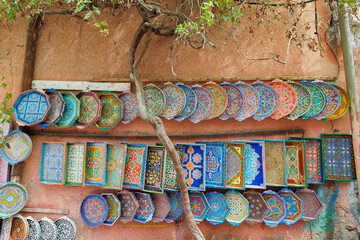 Scenic street view of market stalls and traditional Moroccan plates in the Old Town Medina area of Marrakech, west Morocco
