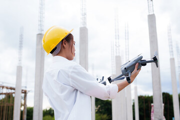 Engineer operating drone at construction site for industrial inspection and surveillance, ensuring...
