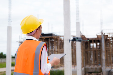 Engineer operating drone at construction site for industrial inspection and surveillance, ensuring...