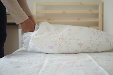 Preparing bed linens in a cozy bedroom setting
