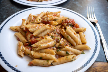 Italian everyday food, cooked pasta penne with tomatoes sauce, garlic and parsley