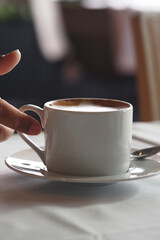 Warm cup of coffee on the table in a cozy cafe setting