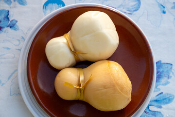 Italian semi hard handmade white and smoked scamorza cheese, from cow milk from Apulia or Calabria regions close up