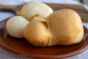 Italian semi hard handmade white and smoked scamorza cheese, from cow milk from Apulia or Calabria...