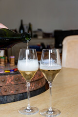 Pouring in glass of white sparkling wine brut, grand reserve, champagne in Ay-Champagne old grand cru wine making village in Vallee de la Marne, Champagne, France