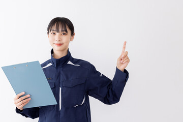 指差しをする作業服の女性
