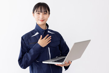 ノートパソコンを使う作業服の女性

