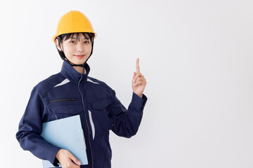 クリップボードを持つ作業服の女性　指差し
