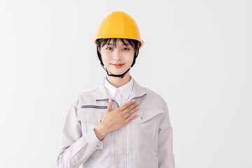 作業服の女性　胸に手を当てる　自信・信頼
