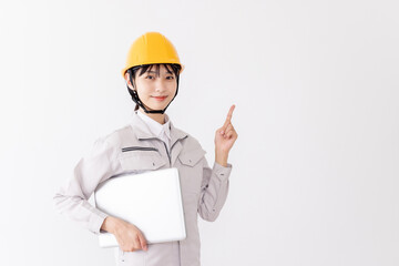 ノートパソコンを持つ作業服の女性　指差し
