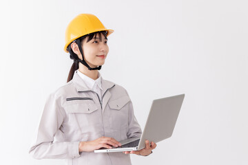 ノートパソコンを使う作業服の女性
