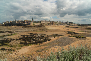View of the fortress city of Saint-Malo on the English Channel and the ocean floor exposed at low tide on a sunny summer day, Brittany, France
