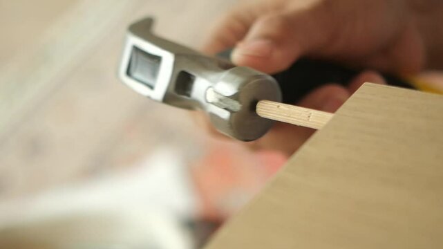 Hammering a wooden dowel in carpentry project at home