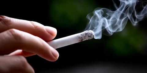 Smoking Cigarette: A close-up shot of a hand holding a burning cigarette, smoke curling upwards against a dark, blurred background.